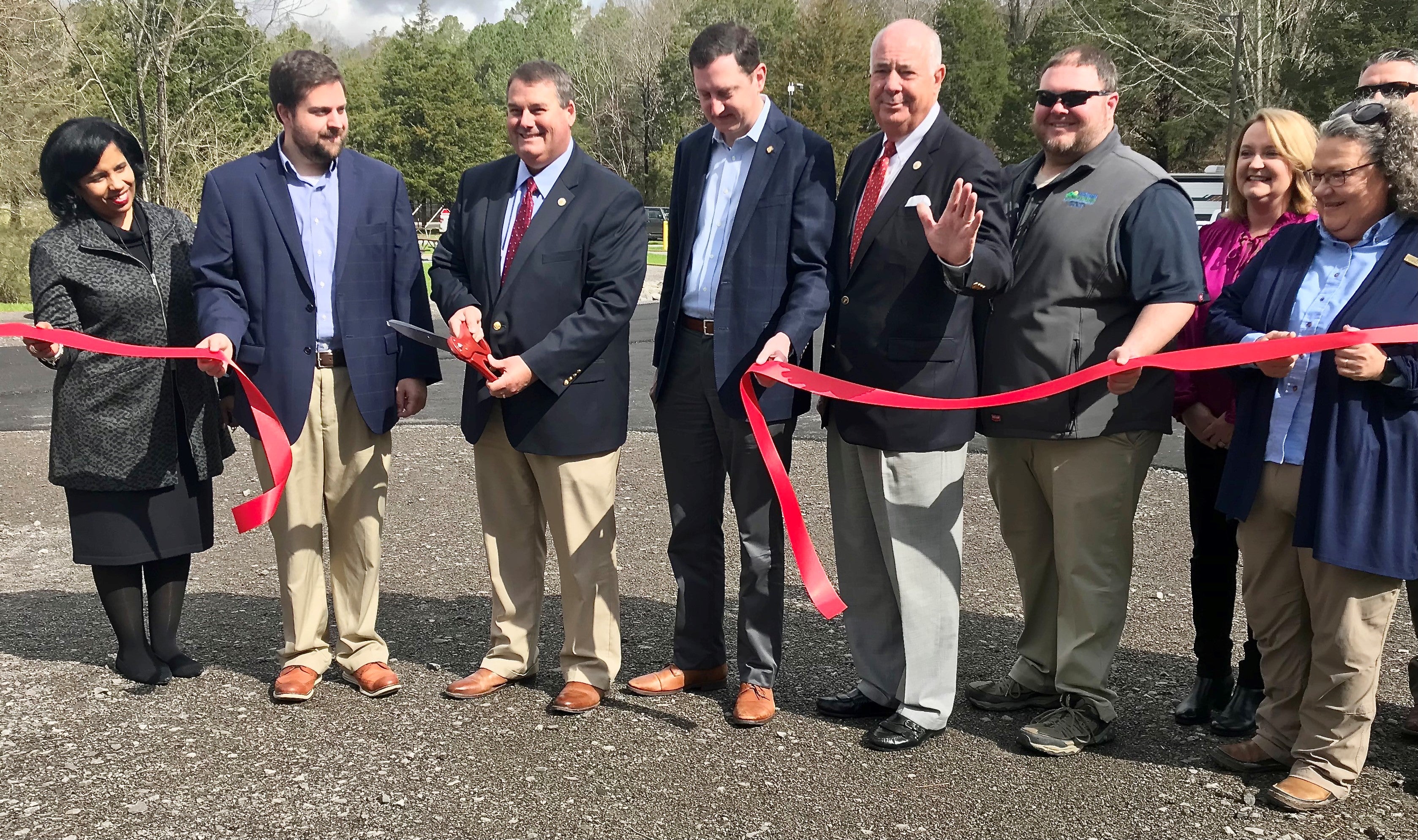 Alabama Department of Conservation and Natural Resources Commissioner Chris Blankenship cuts the ceremonial ribbon to formally open the new campground at Cathedral Caverns State Park. He is flanked by state Rep. Wes Kitchens, state Sen. Clay Scofield, ADECA Director Kenneth Boswell, CCSP Superintendent Chris Bentley, and Katy Norton, president of Marshall County Tourism and Sports.